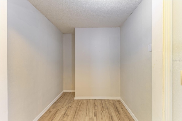 5223 Shadow Lawn Dr, Sarasota, FL 34242 - empty room with light wood-style flooring, a textured ceiling, and baseboards