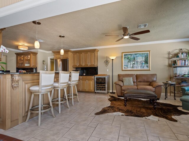 7614 Peninsular Dr, Sarasota, FL 34231 - living room with beverage cooler, crown molding, a ceiling fan, and a textured ceiling