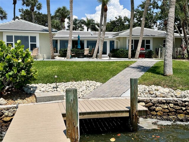 7614 Peninsular Dr, Sarasota, FL 34231 - rear view of house featuring a yard and stucco siding
