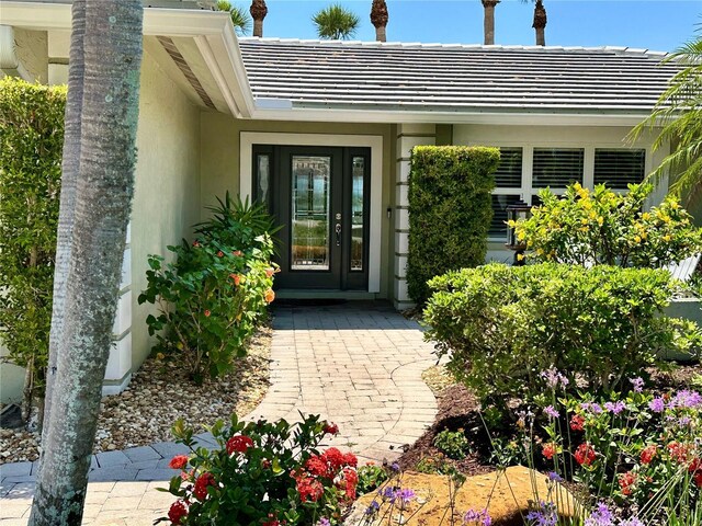 7614 Peninsular Dr, Sarasota, FL 34231 - entrance to property featuring stucco siding and a tile roof