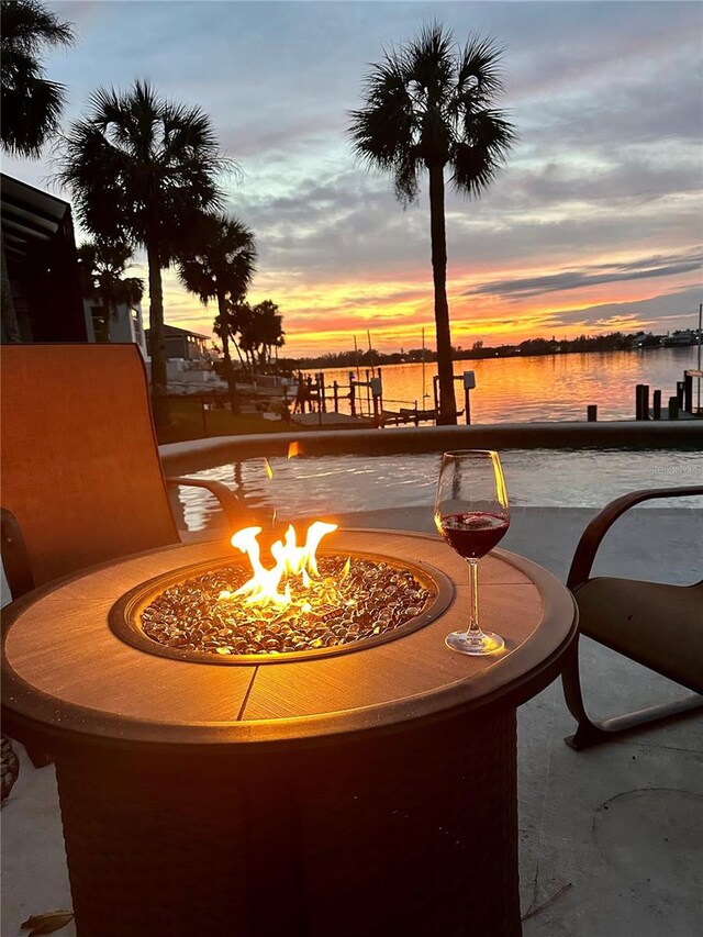 7614 Peninsular Dr, Sarasota, FL 34231 - patio terrace at dusk featuring an outdoor fire pit and a water view