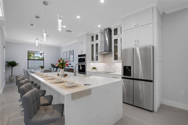 805 Padua Ct, Nokomis, FL 34275 - kitchen with stainless steel appliances, wall chimney range hood, an island with sink, baseboards, and tasteful backsplash