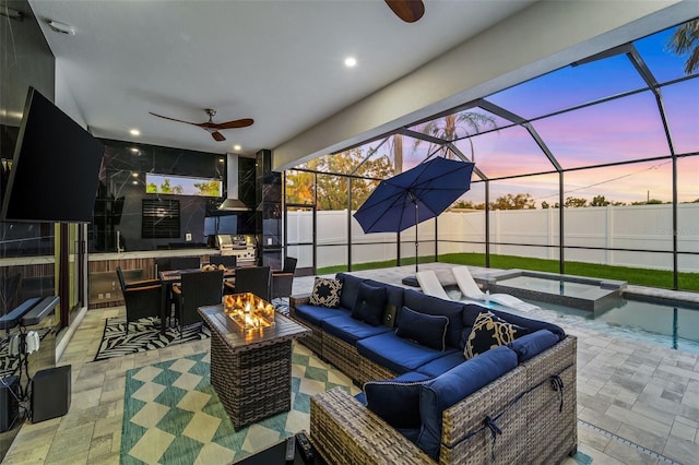 805 Padua Ct, Nokomis, FL 34275 - patio terrace at dusk featuring ceiling fan, an outdoor living space with a fire pit, a patio area, and glass enclosure