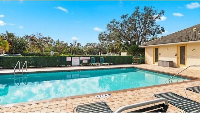 600 Mirabella Cir Unit 201, Venice, FL 34292 - community pool featuring a patio and view of scattered trees