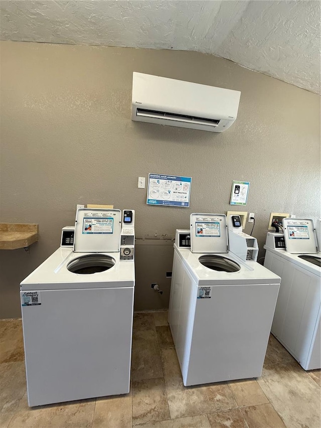 6006 Midnight Pass Rd Unit 48, Sarasota, FL 34242 - shared laundry room with a wall mounted air conditioner, separate washer and dryer, a textured ceiling, and a textured wall