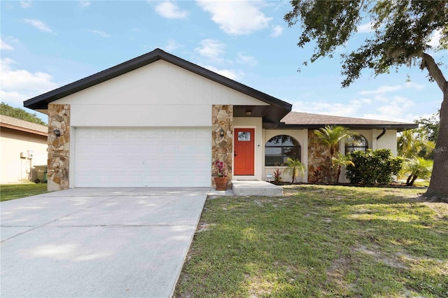 2477 Wood Oak Dr, Sarasota, FL 34232 - single story home with stone siding, an attached garage, a front lawn, and driveway