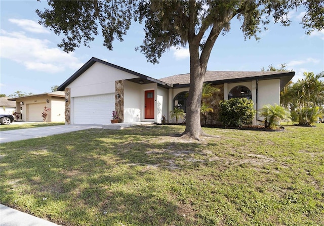 2477 Wood Oak Dr, Sarasota, FL 34232 - view of front facade with a garage, stucco siding, a front yard, and driveway