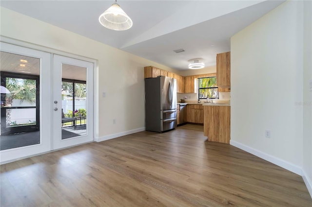 2477 Wood Oak Dr, Sarasota, FL 34232 - kitchen featuring stainless steel appliances, french doors, light countertops, dark wood-style floors, and brown cabinets