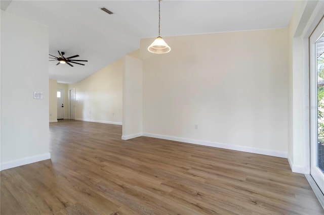 2477 Wood Oak Dr, Sarasota, FL 34232 - spare room featuring plenty of natural light, wood finished floors, vaulted ceiling, baseboards, and a ceiling fan
