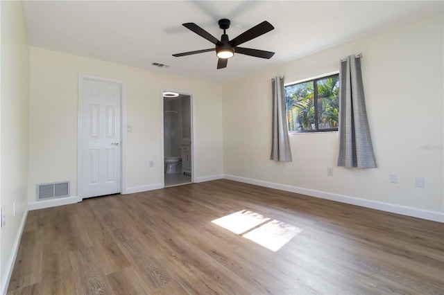 2477 Wood Oak Dr, Sarasota, FL 34232 - unfurnished bedroom with wood finished floors, baseboards, ensuite bath, and ceiling fan