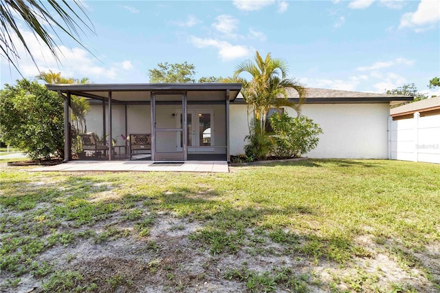 2477 Wood Oak Dr, Sarasota, FL 34232 - back of property with a sunroom, a yard, and stucco siding