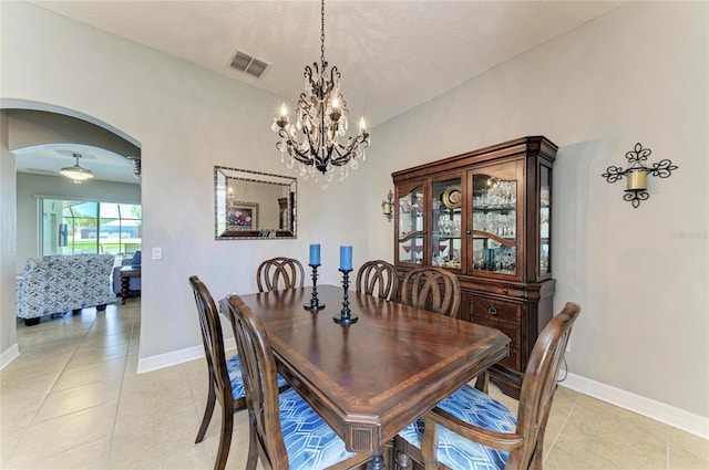 5319 120th Ave E, Parrish, FL 34219 - dining space featuring arched walkways, baseboards, a chandelier, light tile patterned floors, and a textured ceiling