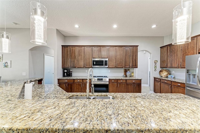5319 120th Ave E, Parrish, FL 34219 - kitchen with appliances with stainless steel finishes, arched walkways, a sink, light stone counters, and recessed lighting
