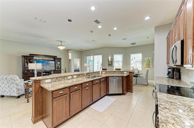5319 120th Ave E, Parrish, FL 34219 - kitchen featuring stainless steel appliances, a sink, light stone countertops, light tile patterned flooring, and brown cabinets