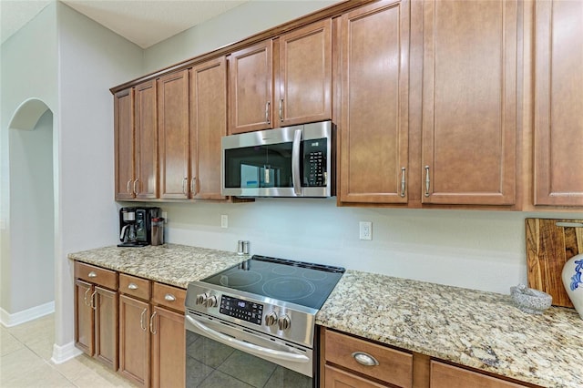 5319 120th Ave E, Parrish, FL 34219 - kitchen featuring appliances with stainless steel finishes, light tile patterned floors, and light stone countertops