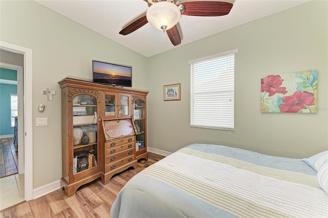 5319 120th Ave E, Parrish, FL 34219 - bedroom with light wood-style flooring, vaulted ceiling, baseboards, multiple windows, and a ceiling fan