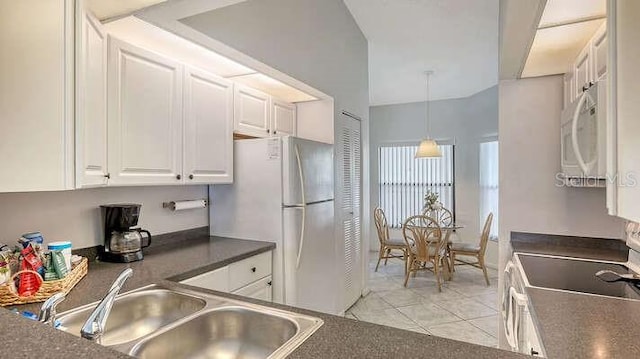 4325 46th Ave W Unit 203, Bradenton, FL 34210 - kitchen featuring white appliances, a sink, white cabinetry, dark countertops, and light tile patterned flooring