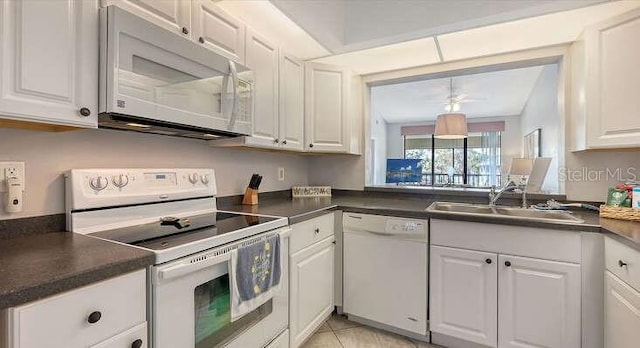 4325 46th Ave W Unit 203, Bradenton, FL 34210 - kitchen with white appliances, white cabinetry, dark countertops, and a sink