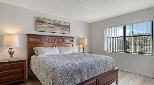 4325 46th Ave W Unit 203, Bradenton, FL 34210 - bedroom with a textured ceiling, light wood-style floors, and baseboards