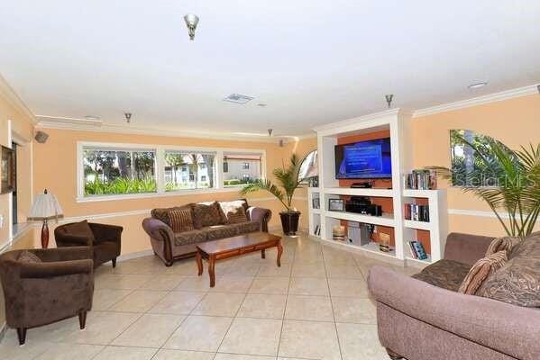 4325 46th Ave W Unit 203, Bradenton, FL 34210 - living area with crown molding, light tile patterned floors, and baseboards