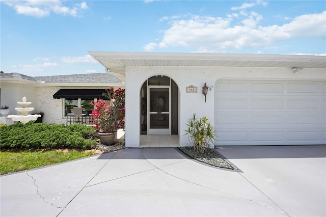 965 E Gondola Dr, Venice, FL 34293 - property entrance featuring an attached garage, stucco siding, and driveway