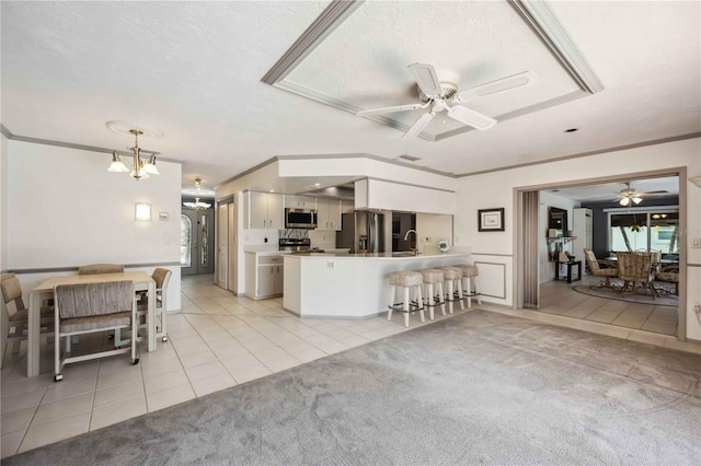 965 E Gondola Dr, Venice, FL 34293 - living area with a ceiling fan, light tile patterned floors, crown molding, a chandelier, and light colored carpet