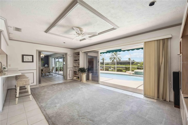 965 E Gondola Dr, Venice, FL 34293 - unfurnished living room with a textured ceiling, healthy amount of natural light, a ceiling fan, light tile patterned floors, and light carpet