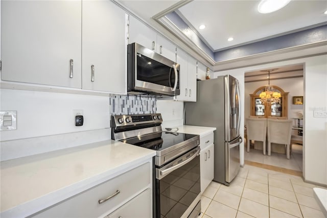965 E Gondola Dr, Venice, FL 34293 - kitchen with stainless steel appliances, a chandelier, light countertops, light tile patterned floors, and a raised ceiling