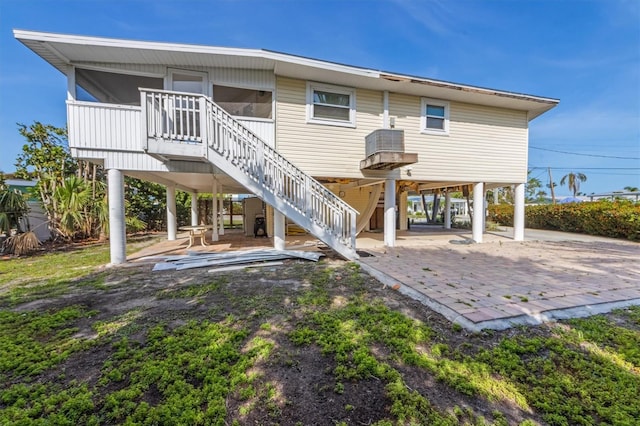 221 85th St, Holmes Beach, FL 34217 - back of property featuring stairs, a patio, and a sunroom