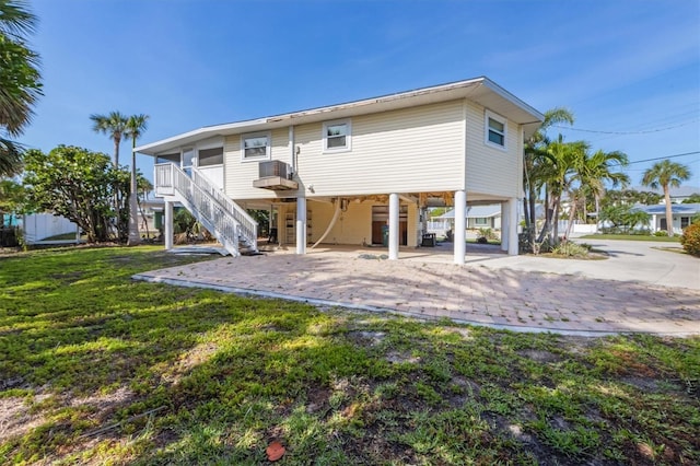221 85th St, Holmes Beach, FL 34217 - rear view of house featuring stairway, a carport, a yard, and driveway