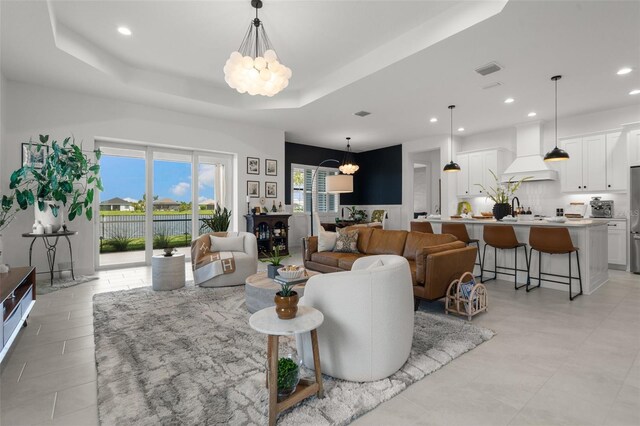 4407 Big Woods Way, Parrish, FL 34219 - living room with a chandelier, recessed lighting, a tray ceiling, and light tile patterned floors