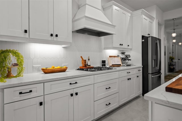4407 Big Woods Way, Parrish, FL 34219 - kitchen with appliances with stainless steel finishes, custom exhaust hood, white cabinets, tasteful backsplash, and light stone countertops