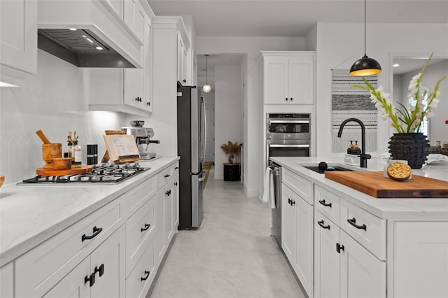 4407 Big Woods Way, Parrish, FL 34219 - kitchen featuring custom range hood, a sink, appliances with stainless steel finishes, white cabinetry, and decorative light fixtures