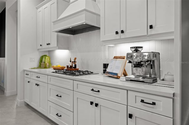 4407 Big Woods Way, Parrish, FL 34219 - kitchen with premium range hood, decorative backsplash, light countertops, white cabinetry, and stainless steel gas cooktop