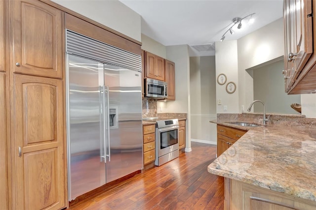4322 Concert St, Port Charlotte, FL 33948 - kitchen with appliances with stainless steel finishes, a sink, dark wood finished floors, light stone counters, and a peninsula