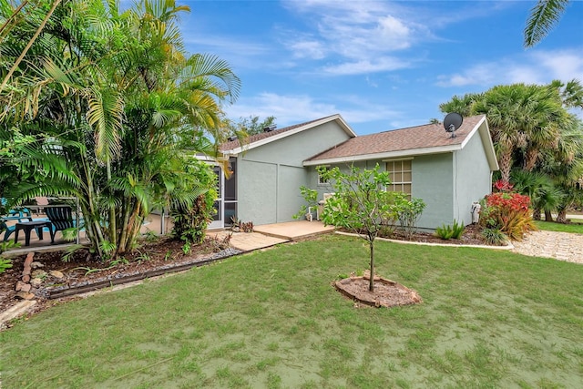 4322 Concert St, Port Charlotte, FL 33948 - view of side of property with a lawn, stucco siding, and a patio area