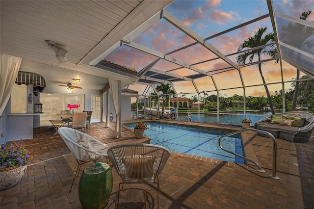 572 Commonwealth Ln, Sarasota, FL 34242 - pool at dusk with an outdoor pool, a patio area, a water view, and glass enclosure