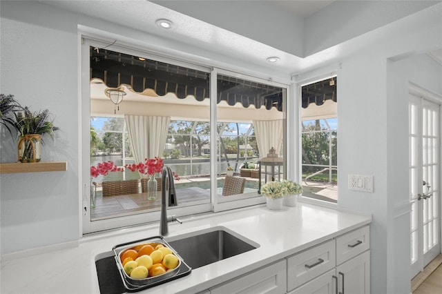 572 Commonwealth Ln, Sarasota, FL 34242 - kitchen featuring a sink, plenty of natural light, white cabinetry, light countertops, and recessed lighting