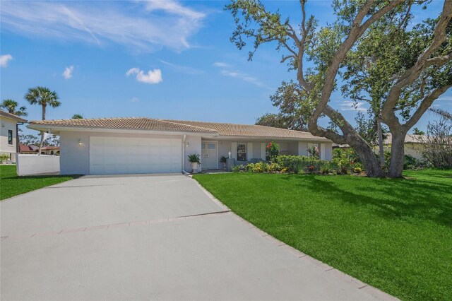 572 Commonwealth Ln, Sarasota, FL 34242 - ranch-style home with a tile roof, driveway, a garage, a front lawn, and stucco siding