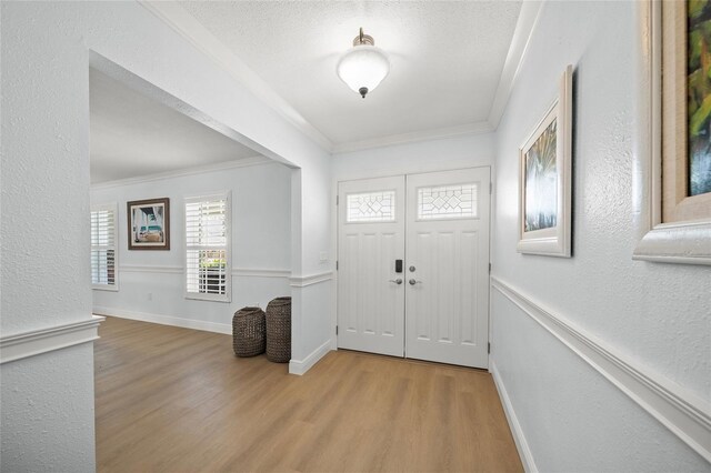 572 Commonwealth Ln, Sarasota, FL 34242 - entryway featuring crown molding, wood finished floors, healthy amount of natural light, a textured wall, and baseboards