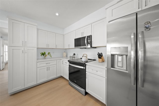 572 Commonwealth Ln, Sarasota, FL 34242 - kitchen featuring stainless steel appliances, light wood-type flooring, light countertops, white cabinetry, and recessed lighting