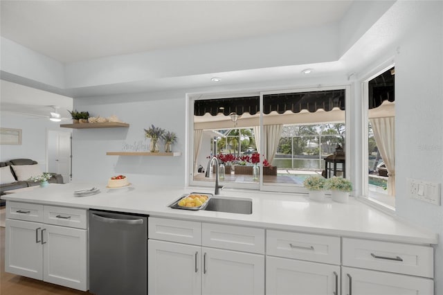 572 Commonwealth Ln, Sarasota, FL 34242 - kitchen featuring stainless steel dishwasher, white cabinetry, open shelves, light countertops, and a sink