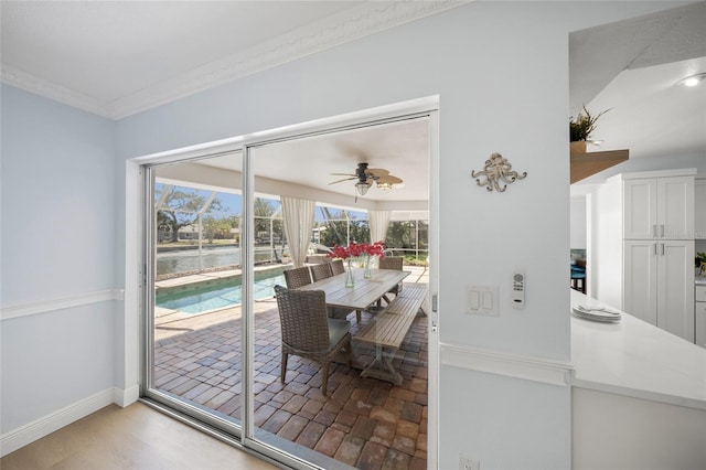 572 Commonwealth Ln, Sarasota, FL 34242 - dining area featuring crown molding, ceiling fan, baseboards, and light wood-style flooring