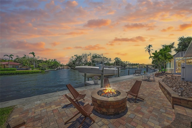 572 Commonwealth Ln, Sarasota, FL 34242 - patio terrace at dusk with an outdoor fire pit, a patio, a boat dock, and a water view
