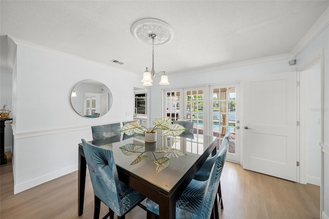572 Commonwealth Ln, Sarasota, FL 34242 - dining room featuring light wood-type flooring, a chandelier, ornamental molding, and baseboards