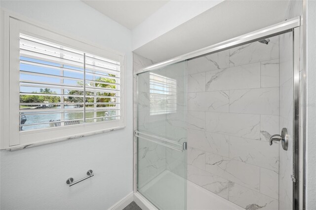 572 Commonwealth Ln, Sarasota, FL 34242 - full bath featuring a water view, a shower with shower door, and baseboards