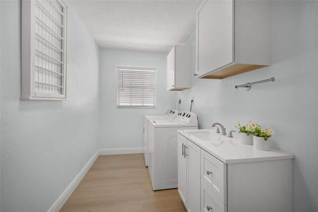 572 Commonwealth Ln, Sarasota, FL 34242 - laundry area featuring separate washer and dryer, cabinet space, light wood-type flooring, and baseboards