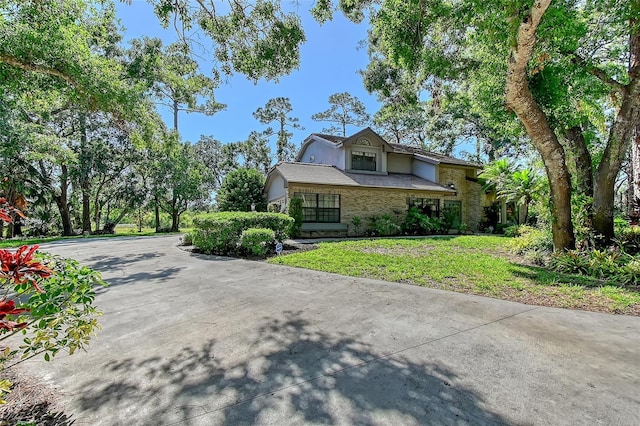 4917 Leatha Ln, Sarasota, FL 34232 - view of front facade with stucco siding, driveway, and stone siding