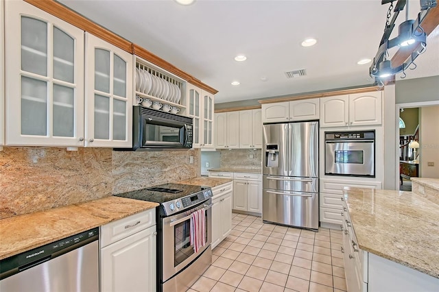 4917 Leatha Ln, Sarasota, FL 34232 - kitchen with stainless steel appliances, light tile patterned floors, decorative backsplash, recessed lighting, and white cabinets