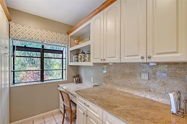 4917 Leatha Ln, Sarasota, FL 34232 - kitchen with light tile patterned flooring, backsplash, light stone countertops, white cabinetry, and open shelves